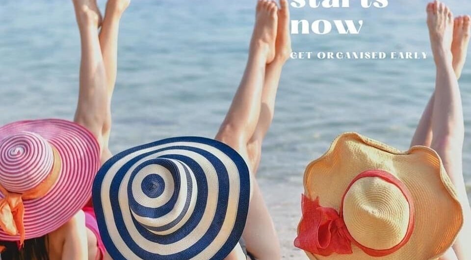 Three women in hats relax on a beach at Beauty by Caroline, Silsoe, England, GB.