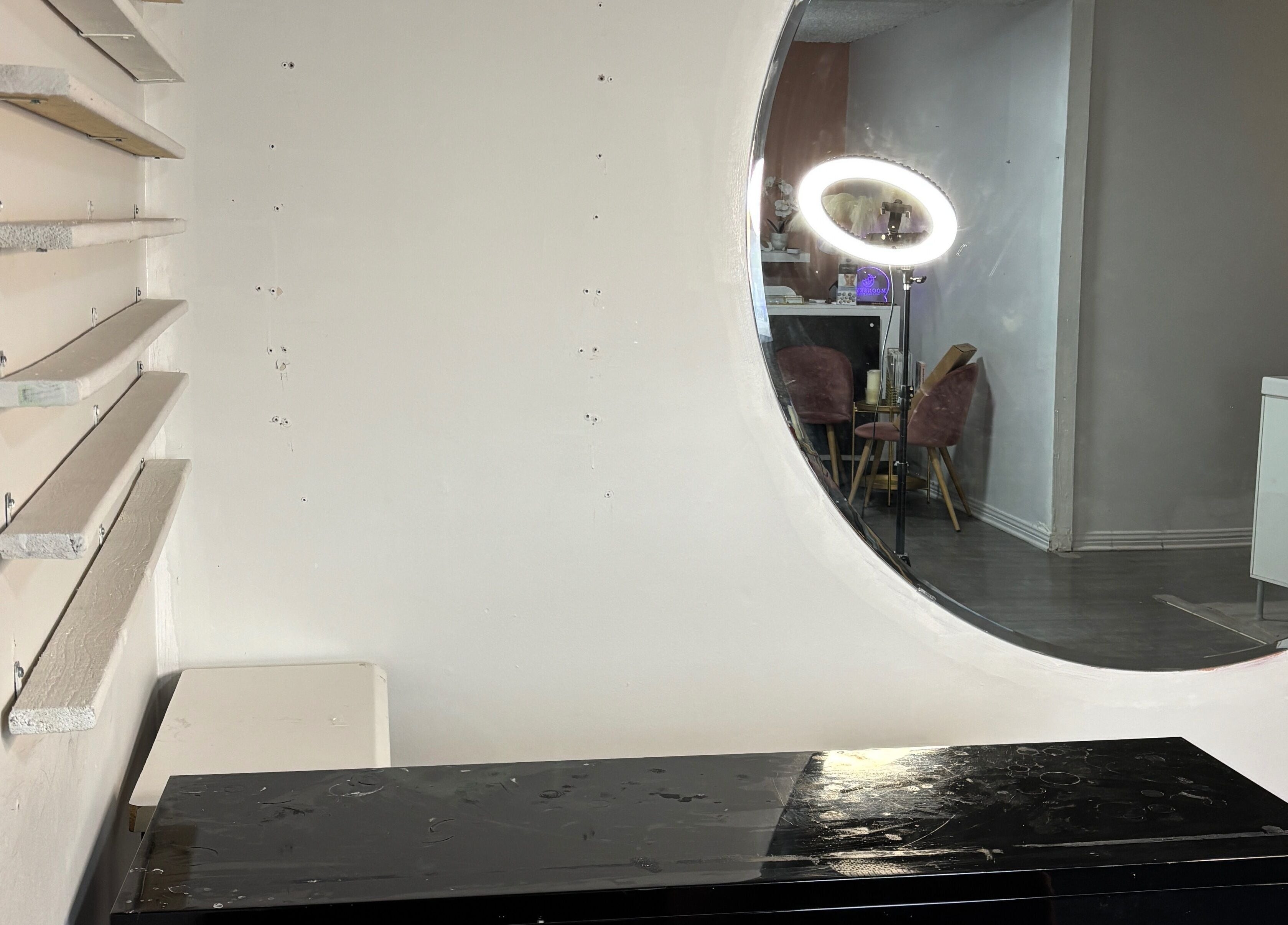 Interior of Moonskyn, Montréal, showcasing a sleek design with a round mirror and elegant seating arrangement.