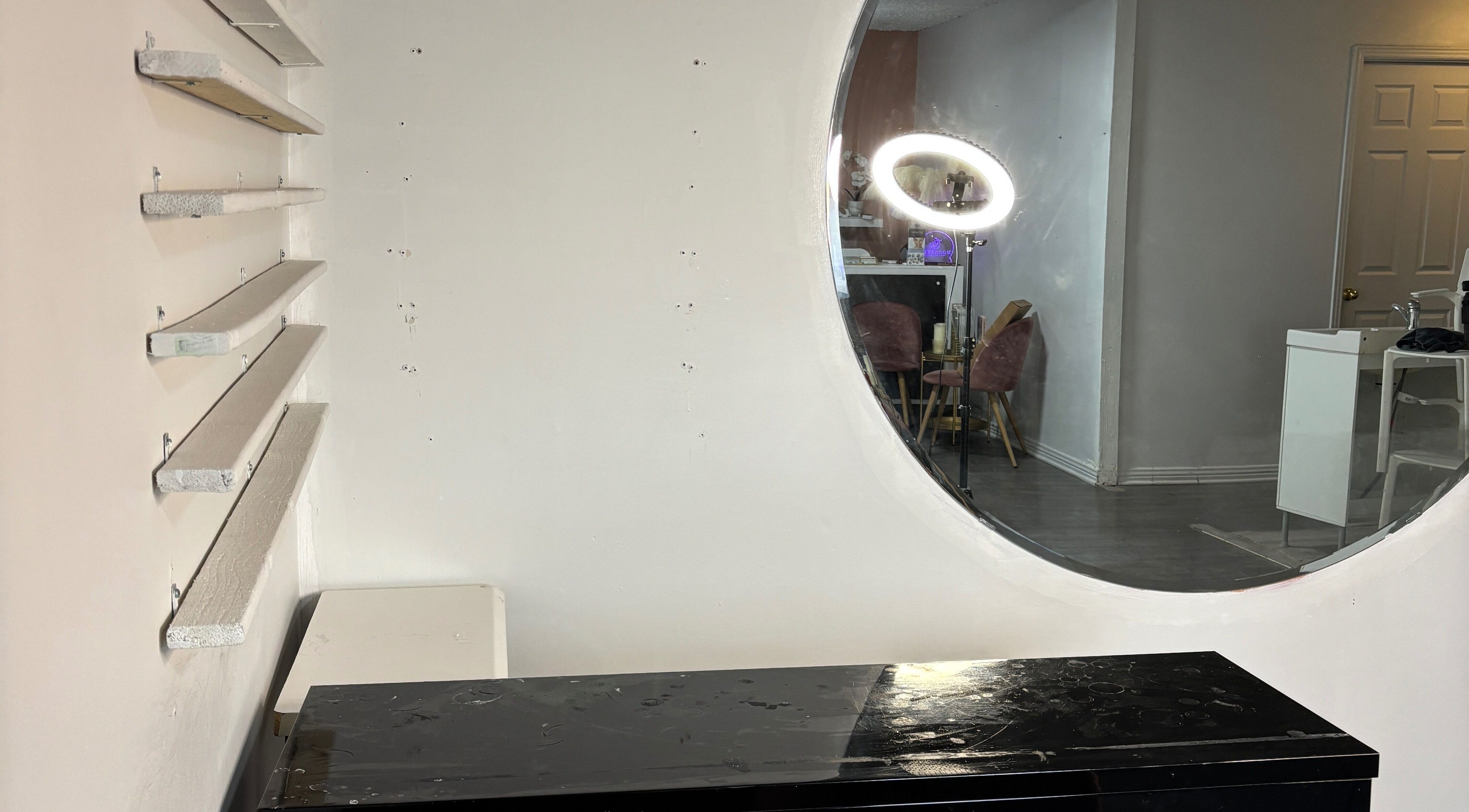 Interior of Moonskyn, Montréal, showcasing a sleek design with a round mirror and elegant seating arrangement.