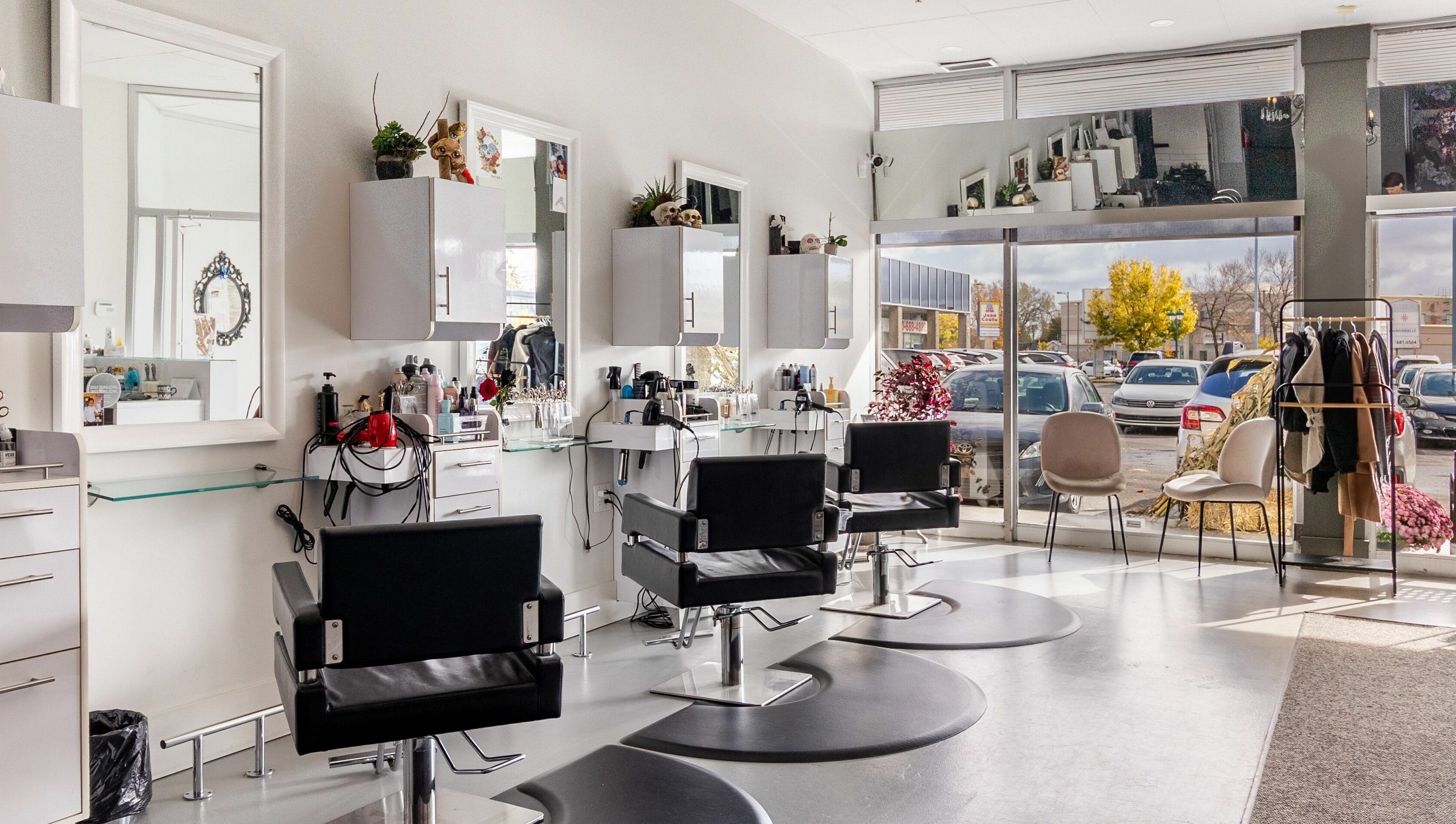 Bright, stylish interior of Lolo's Salon in Laval, Québec, CA featuring sleek black chairs and spacious layout.