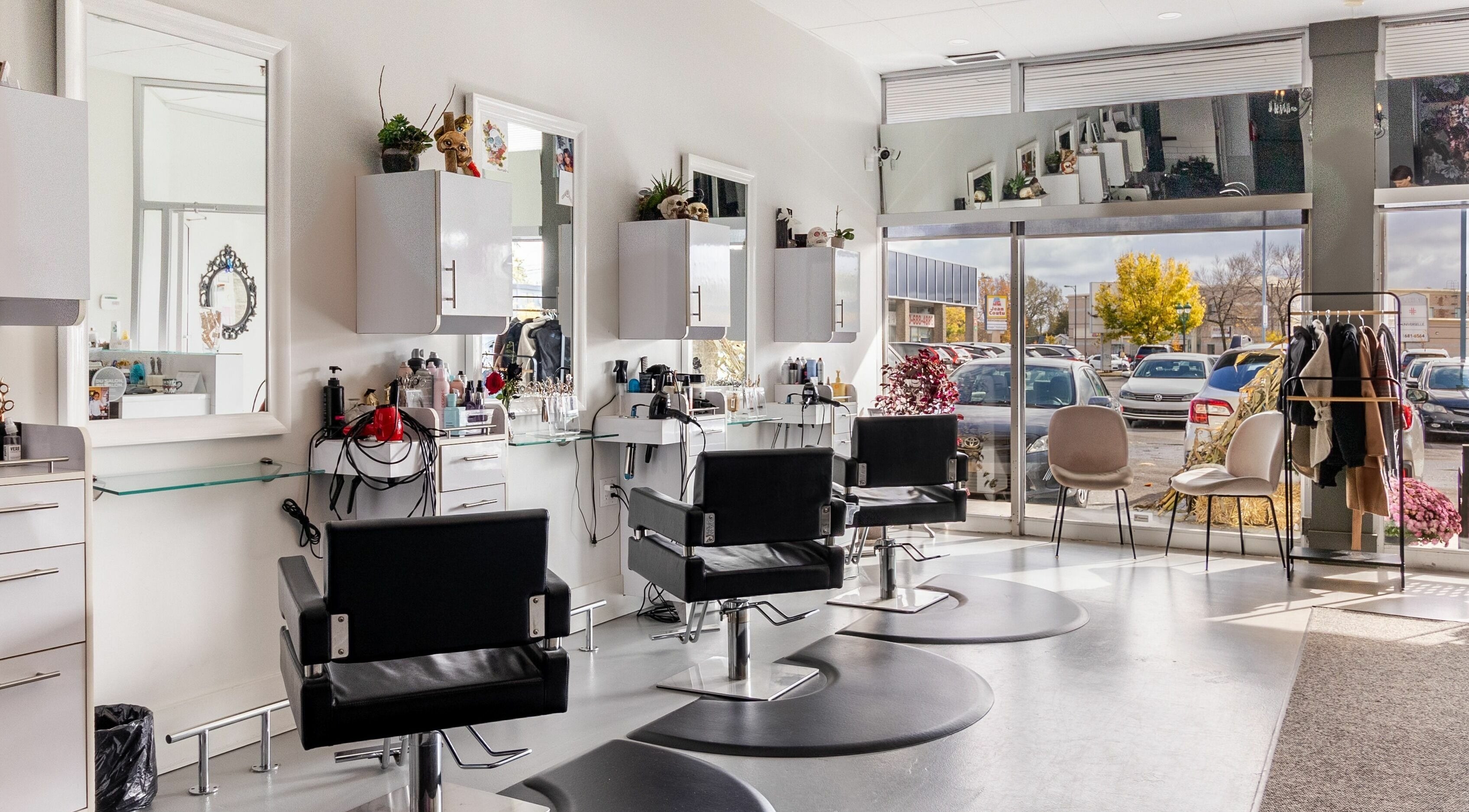 Bright, stylish interior of Lolo's Salon in Laval, Québec, CA featuring sleek black chairs and spacious layout.