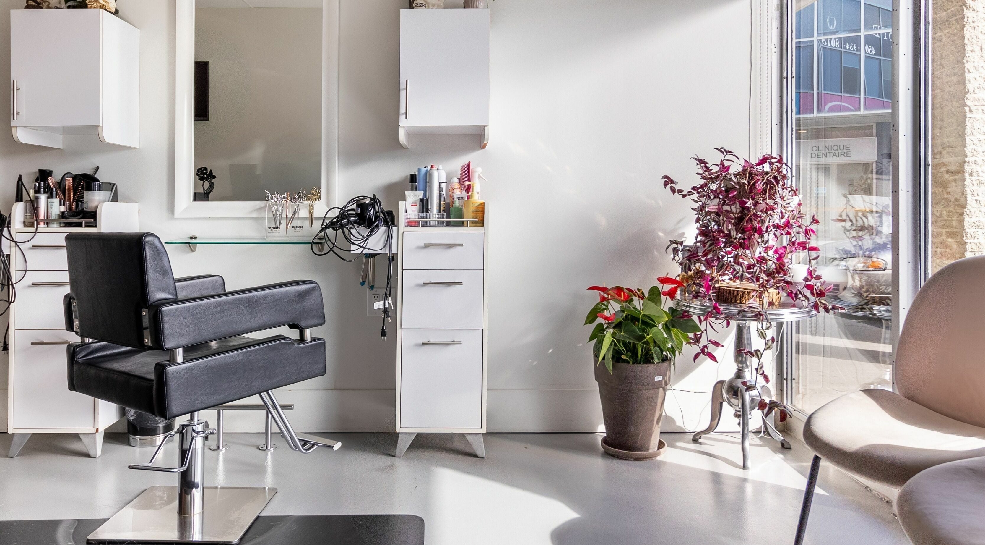 Modern salon chair at Lolo's Salon in Laval, Québec, CA, with vibrant plants and sleek decor.