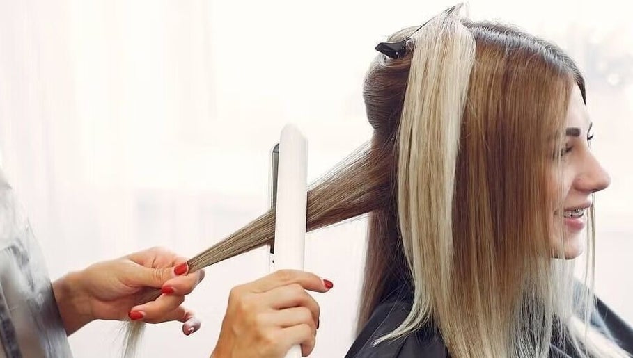 Stylist straightens hair at Passion Salon & Spa (Hill Avenue), Regina, Saskatchewan, CA.