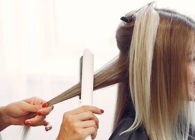 Stylist straightens hair at Passion Salon & Spa (Hill Avenue), Regina, Saskatchewan, CA.