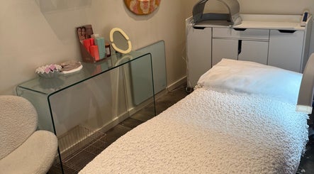 Cozy treatment room at That Glow, Melbourne, Victoria, AU with plush bed and skincare products on display.