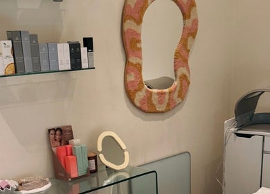 Stylish skincare room at That Glow, Melbourne, Victoria, AU featuring products and a decorative mirror.
