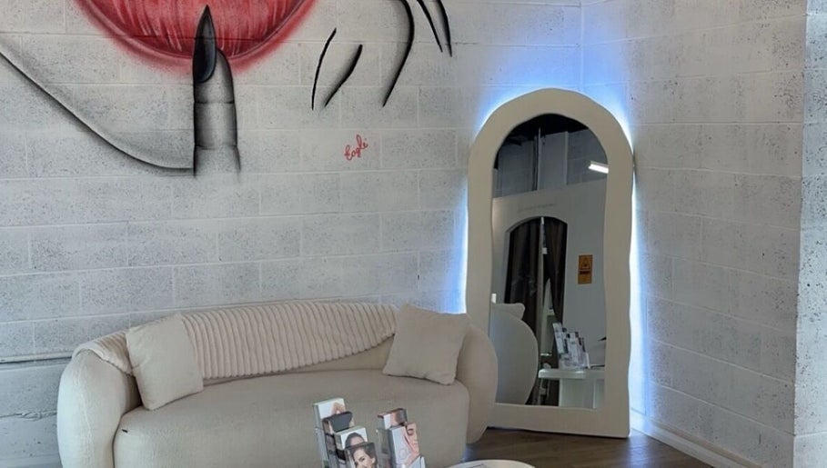 Chic lounge in Epidermis, Panania, New South Wales with a modern sofa and mirror.