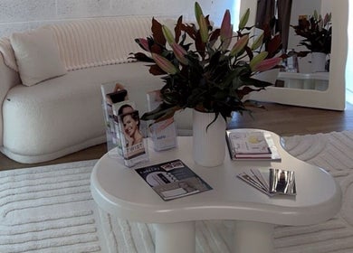 Stylish lounge at Epidermis, Panania, New South Wales, AU with cream sofa, elegant flowers, and product brochures.
