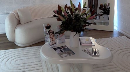 Stylish lounge at Epidermis, Panania, New South Wales, AU with cream sofa, elegant flowers, and product brochures.