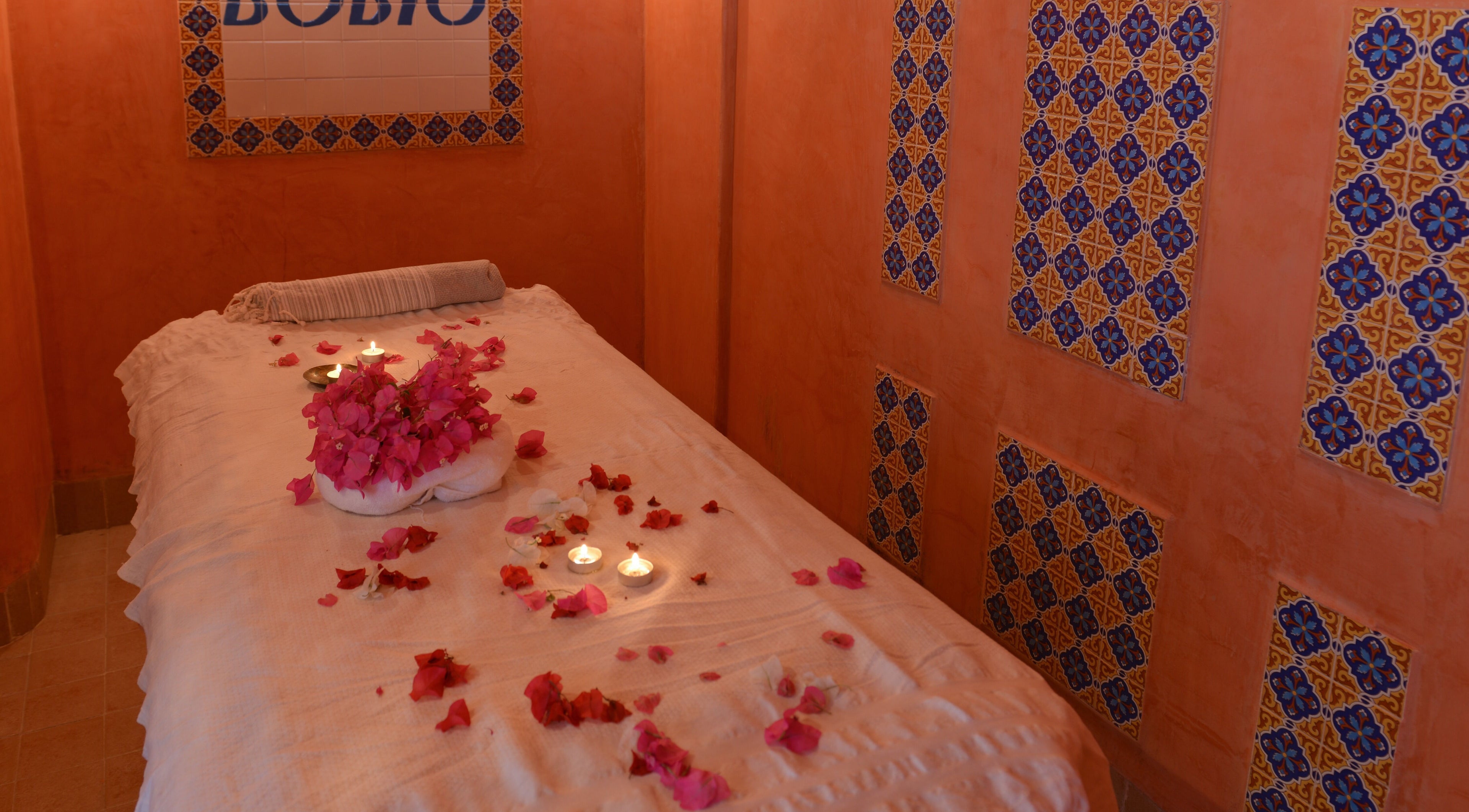 Salle de massage avec bougies et pétales à Nabeul, نابل, TN, ambiance relaxante et apaisante.