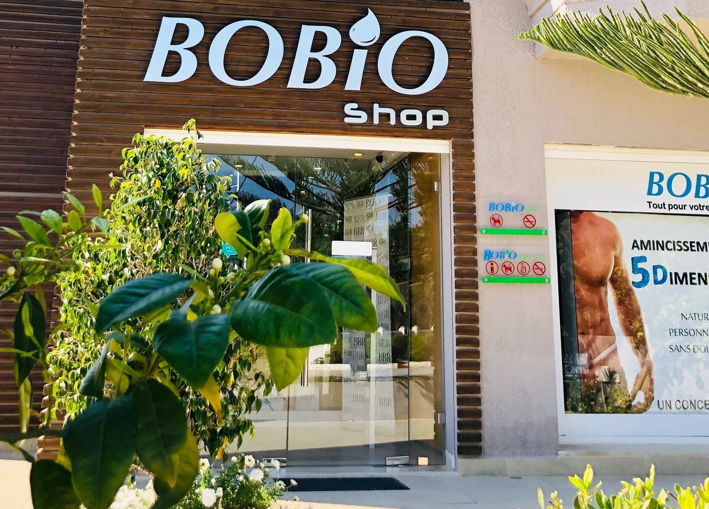 Entrée de la boutique Bobio à Nabeul, نابل, TN, entourée de verdure luxuriante.