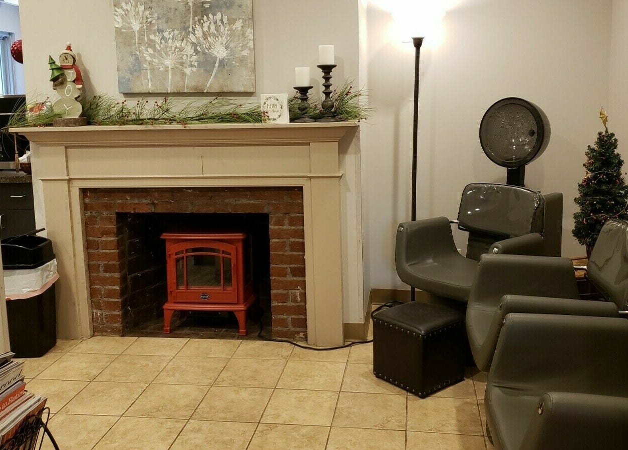 Relaxing seating area at Raymond Salon N Spa, Franklin Township, New Jersey, US, with fireplace and decor.