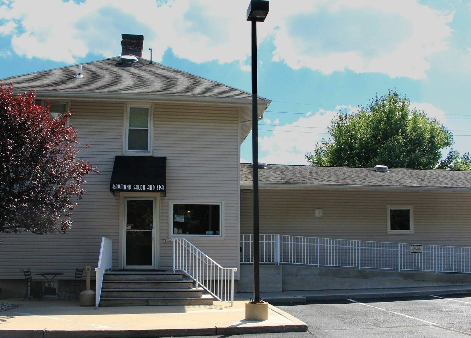 Front facade of Raymond Salon N Spa in Franklin Township, New Jersey, US under a bright blue sky.