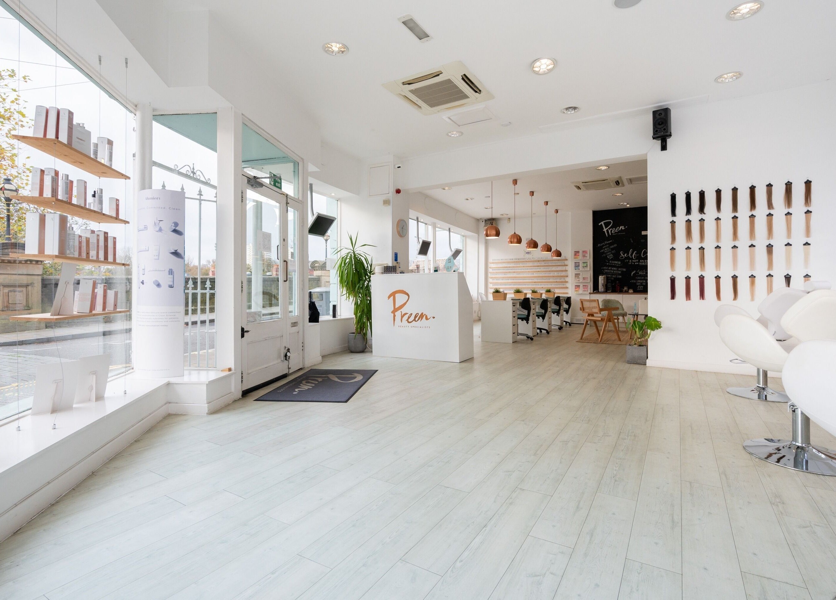 Elegant interior of Preen salon in Stockport, England, GB with modern decor and ample natural light.
