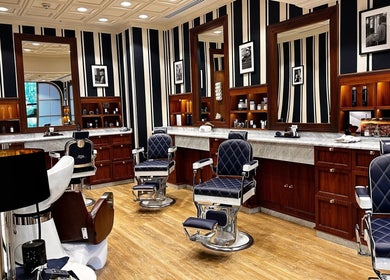 Interior of Barberia Italiana Grooming Lounge Ltd. in Dubai, Dubai, AE with luxurious barber chairs and wooden decor.