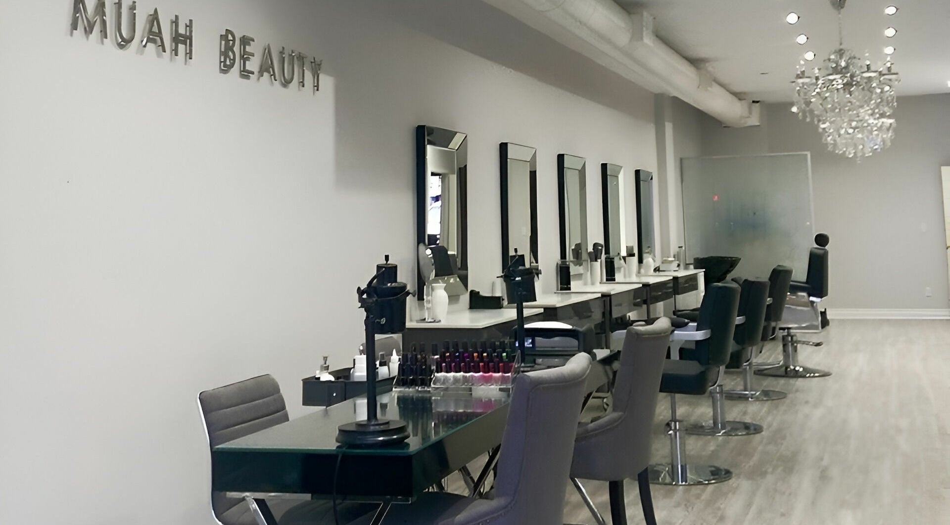 Modern salon at Muah Beauty, Toronto, Ontario, CA with sleek chairs and mirrors under elegant lighting.