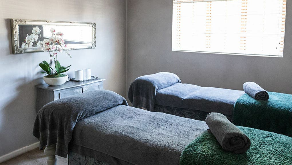 Tranquil massage room at Gingerlily Spa, Cape Town, Western Cape, ZA with two massage beds and orchid decor.