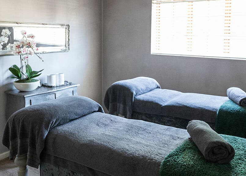 Tranquil massage room at Gingerlily Spa, Cape Town, Western Cape, ZA with two massage beds and orchid decor.