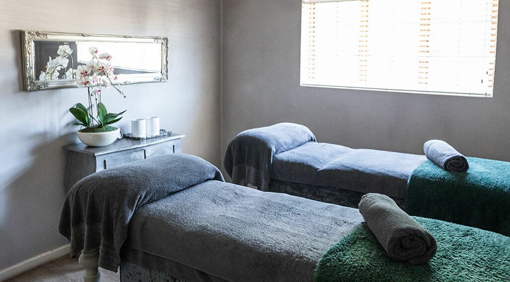 Tranquil massage room at Gingerlily Spa, Cape Town, Western Cape, ZA with two massage beds and orchid decor.