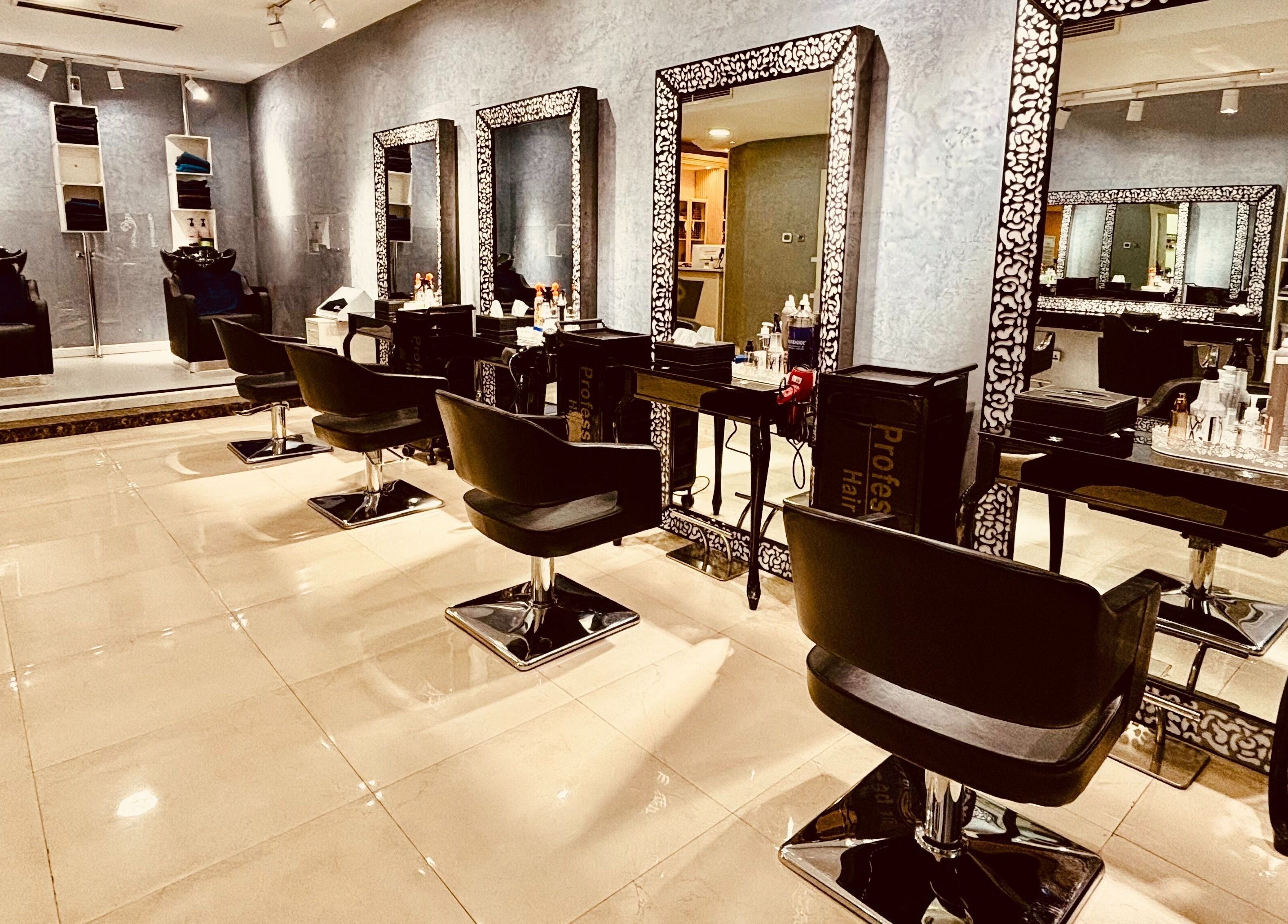 Chic interior of Glitz Beauty Center in Dubai, AE showcasing luxurious salon chairs and mirrors.