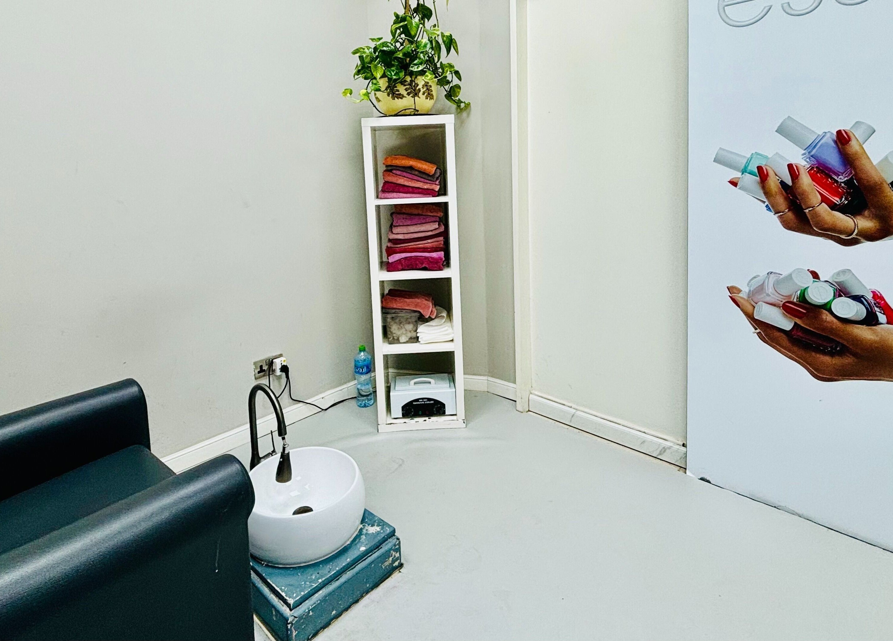 Modern nail care station at Glitz Beauty Center, Dubai, AE showcasing seating and supplies.