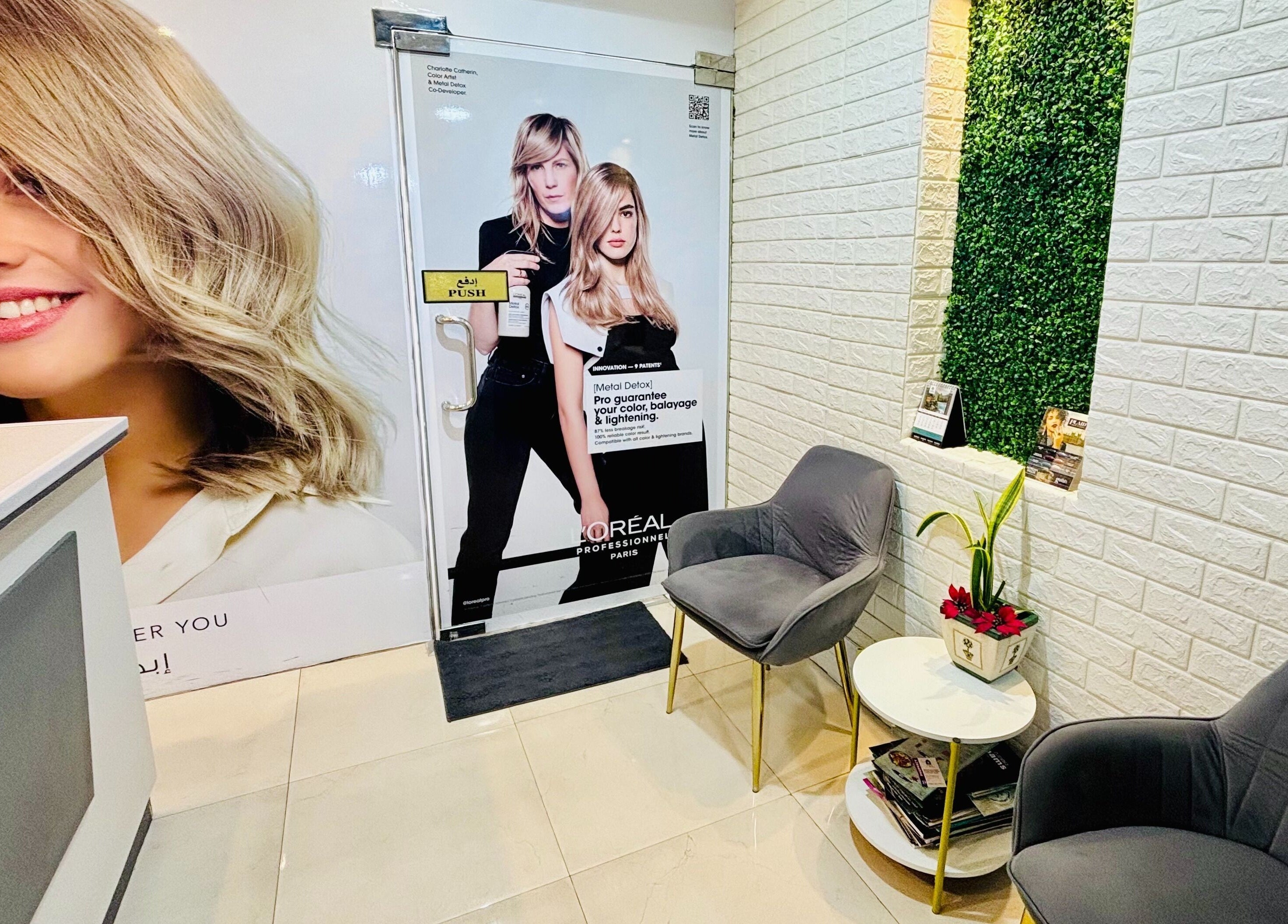 Lobby of Glitz Beauty Center in Dubai, AE featuring chic seating and promotional hair care posters.