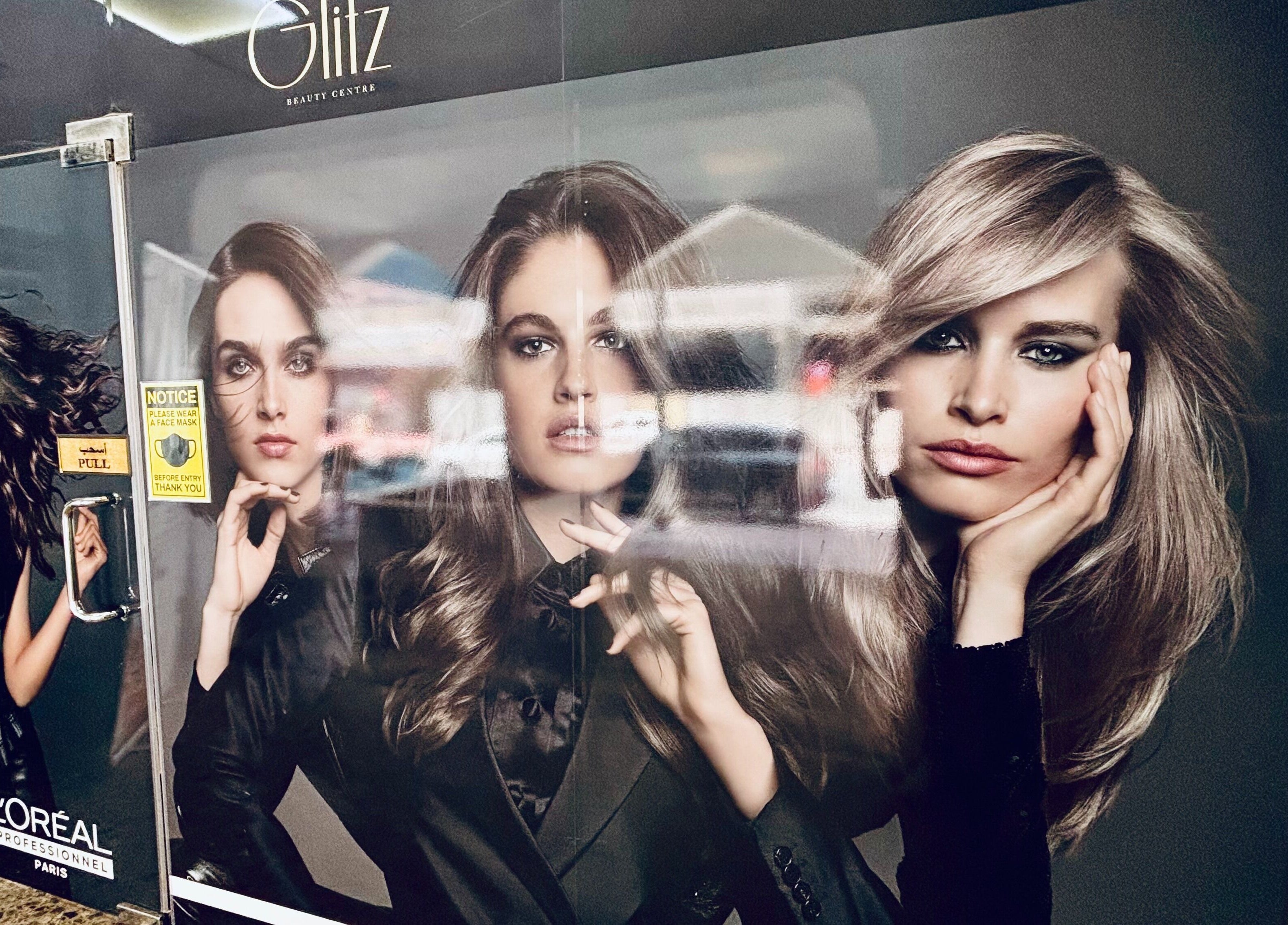 Entrance of Glitz Beauty Center in Dubai, AE featuring chic L'Oreal promotional models.