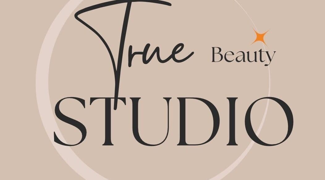 Logo of True Beauty Studio in Brighton, England, GB with elegant typography on beige background.