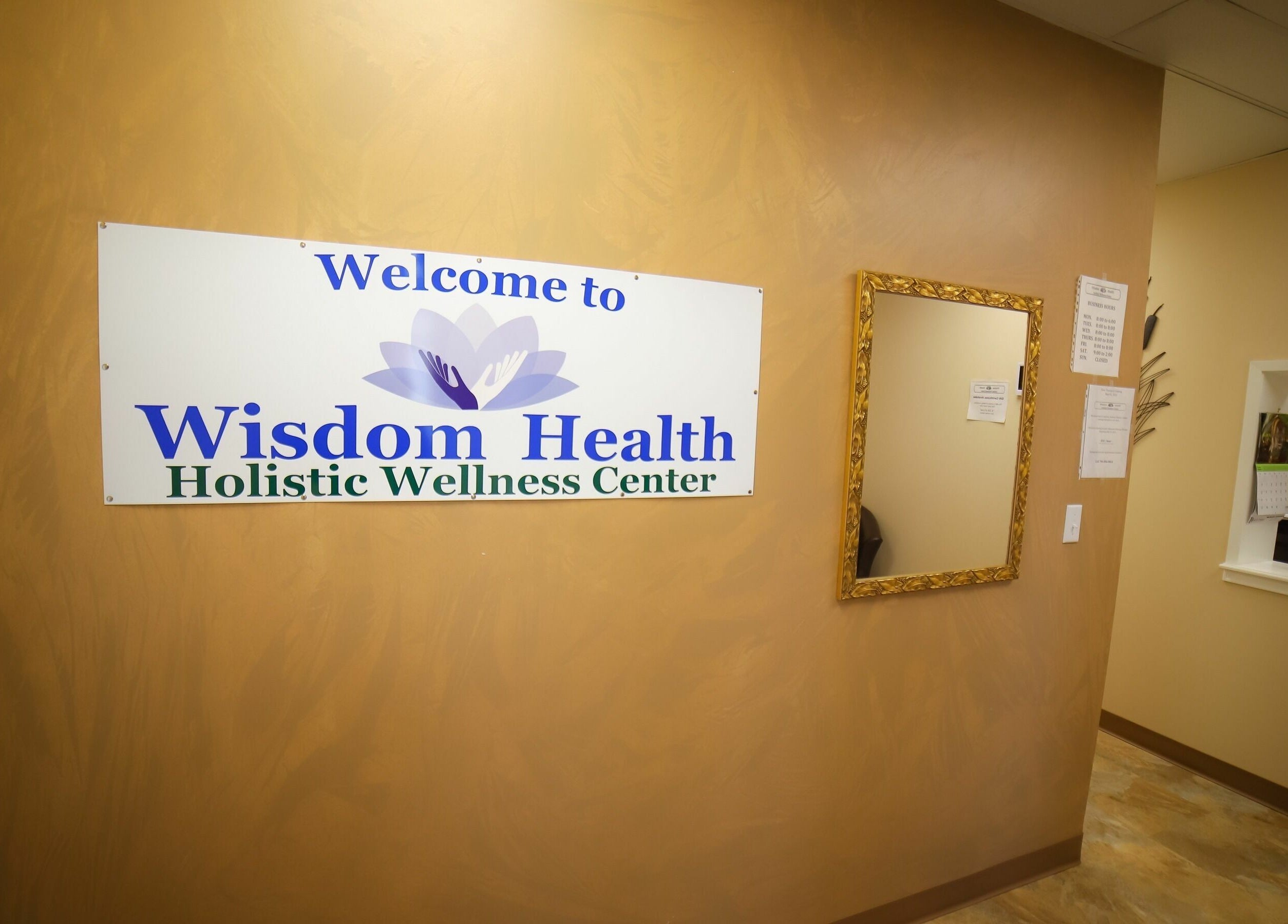 Entrance of Wisdom Health Holistic Wellness Center in Wainwright, Alberta, CA with welcome sign and mirror.