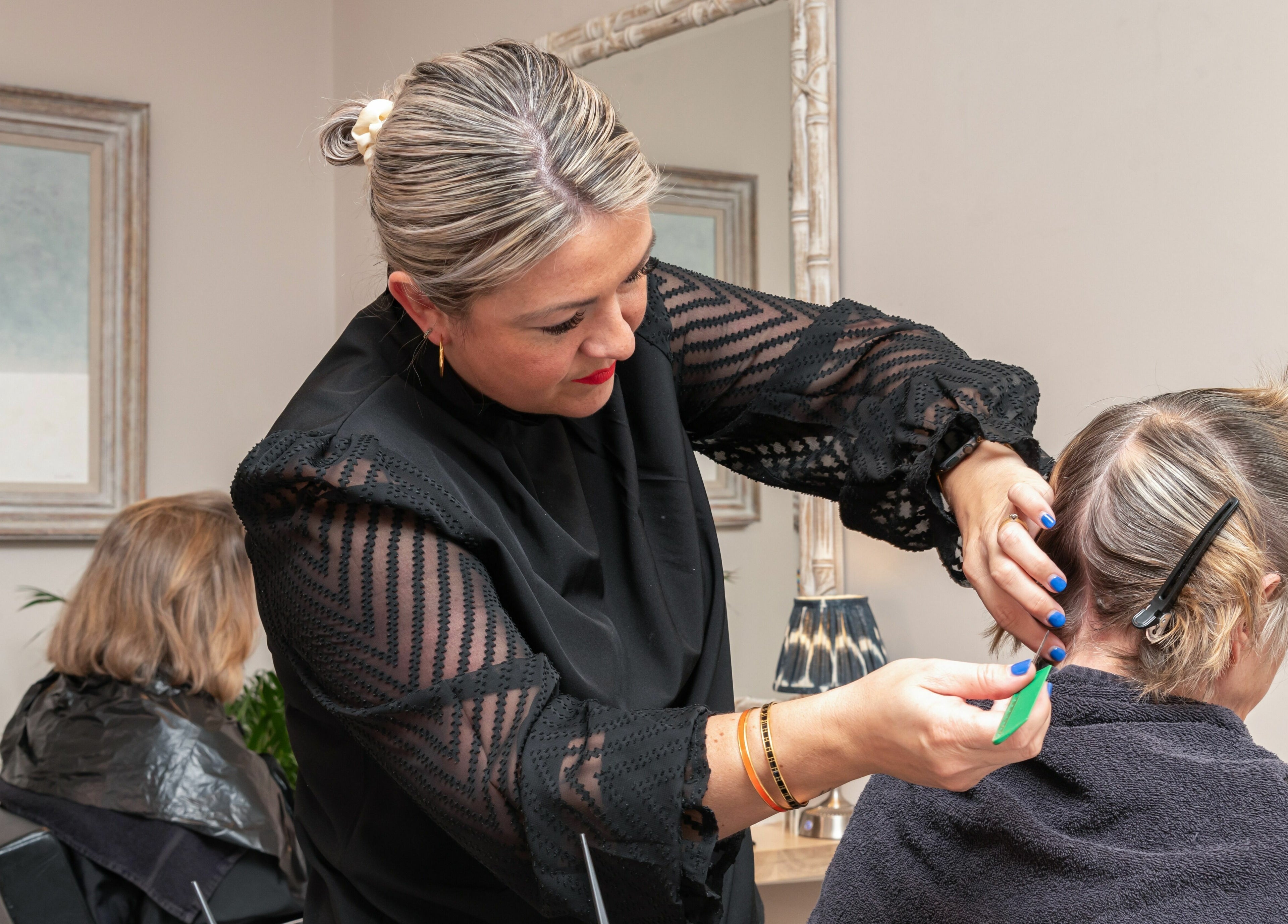 Stylist at Elcot Park Retreat, Newbury, England, GB, creating a chic hairstyle for client.
