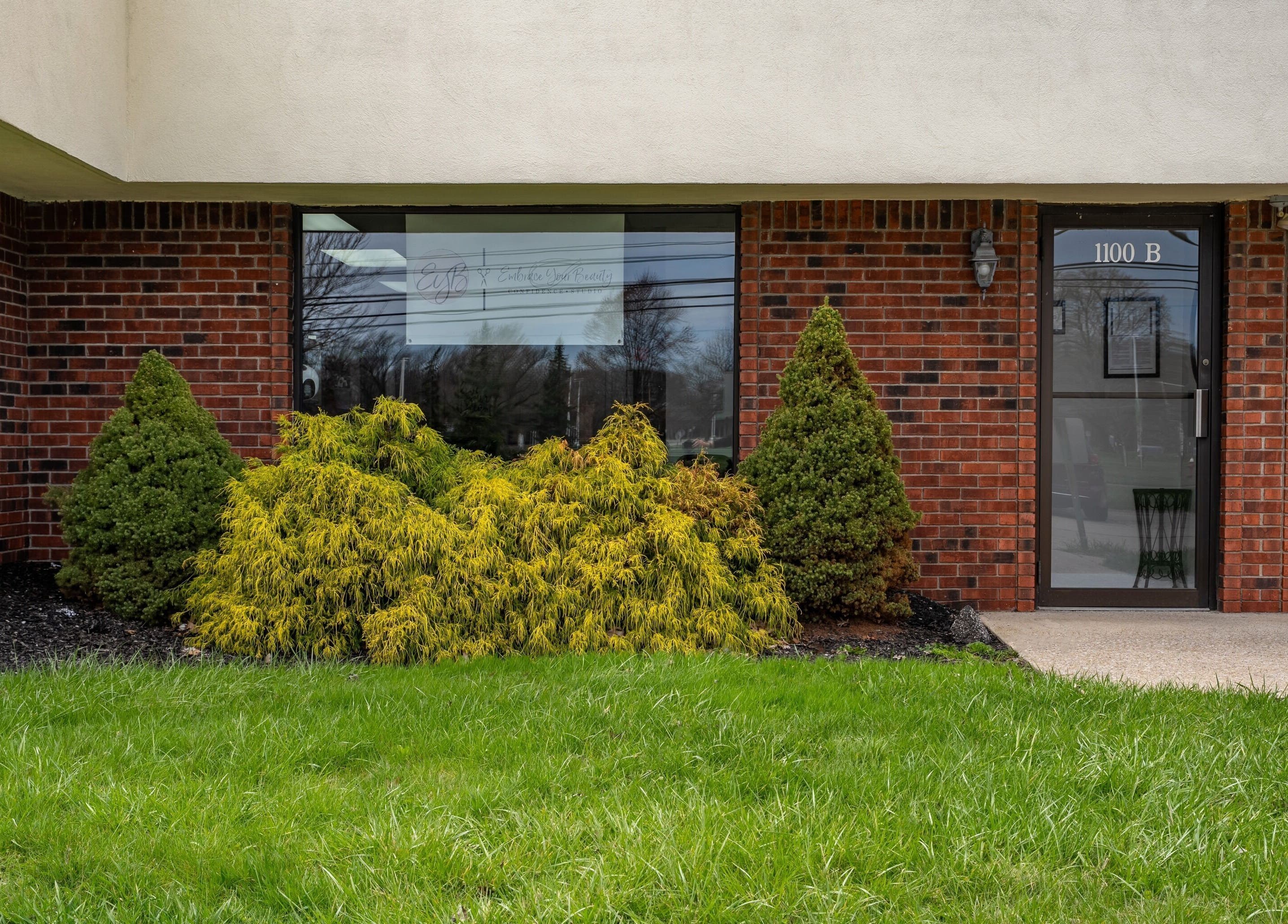 Front view of EYB Confidence Studio, surrounded by vibrant greenery in Elyria, Ohio, US.