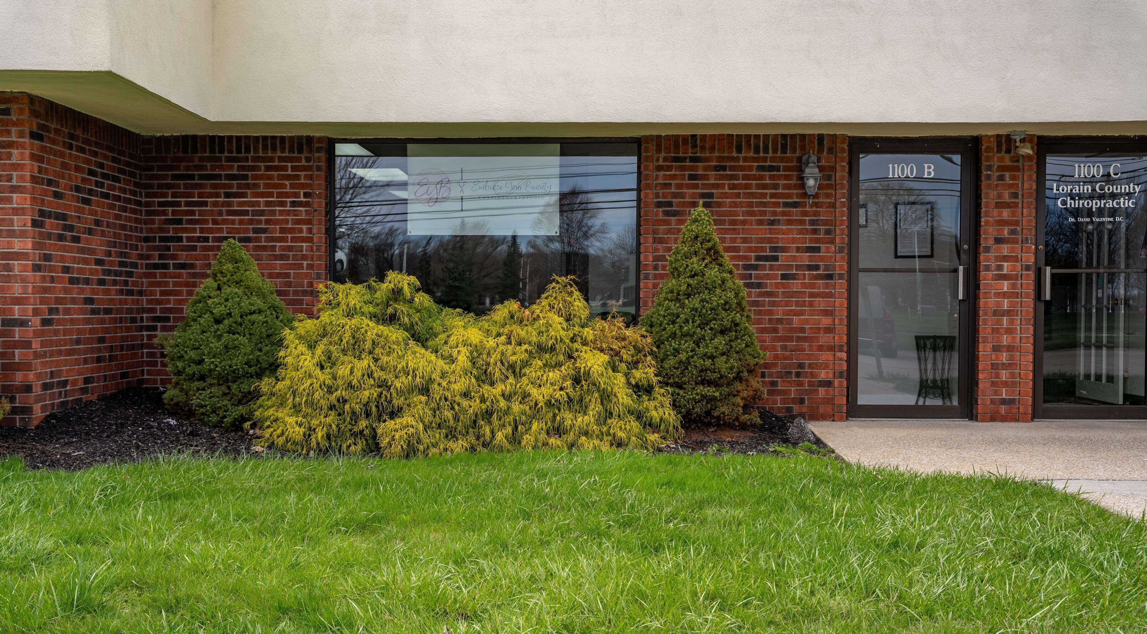 Front view of EYB Confidence Studio, surrounded by vibrant greenery in Elyria, Ohio, US.