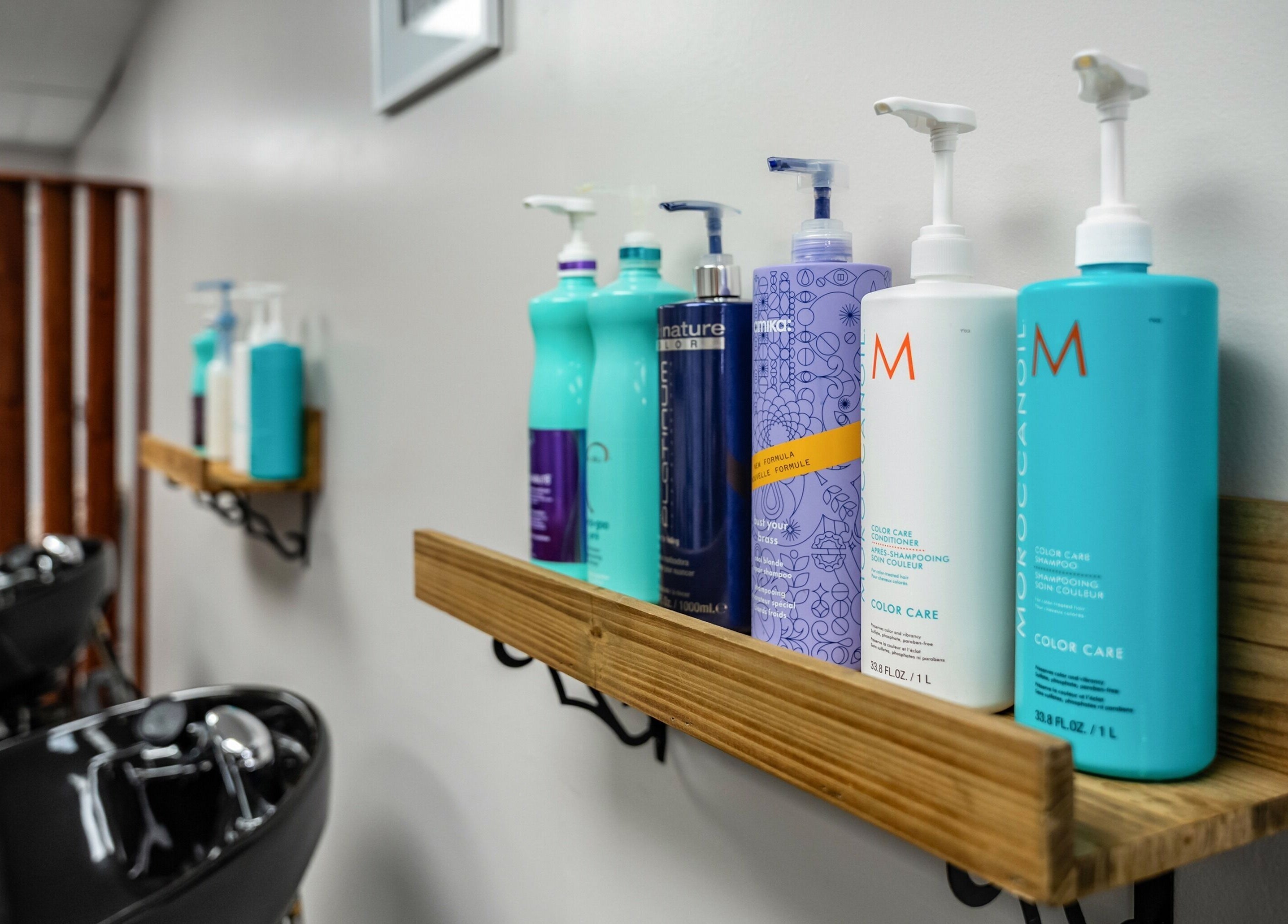 Colorful shampoo bottles on wooden shelves at EYB Confidence Studio, Elyria, Ohio, US, enhance salon ambiance.