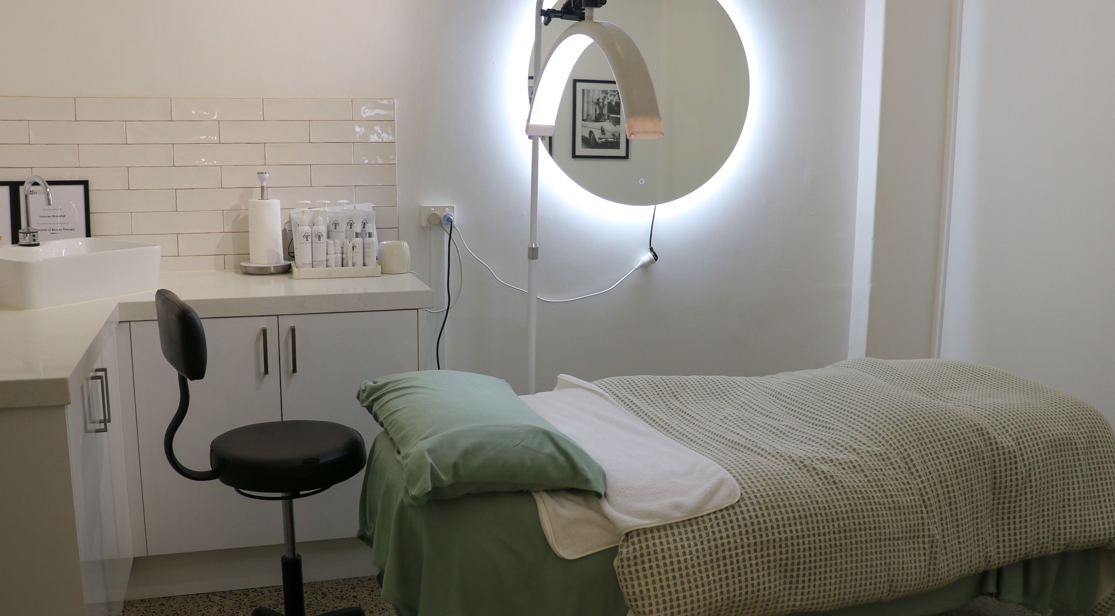 Modern spa room at Waterfall Beauty, Melbourne, Victoria, AU, featuring a cozy treatment bed and ambient lighting.