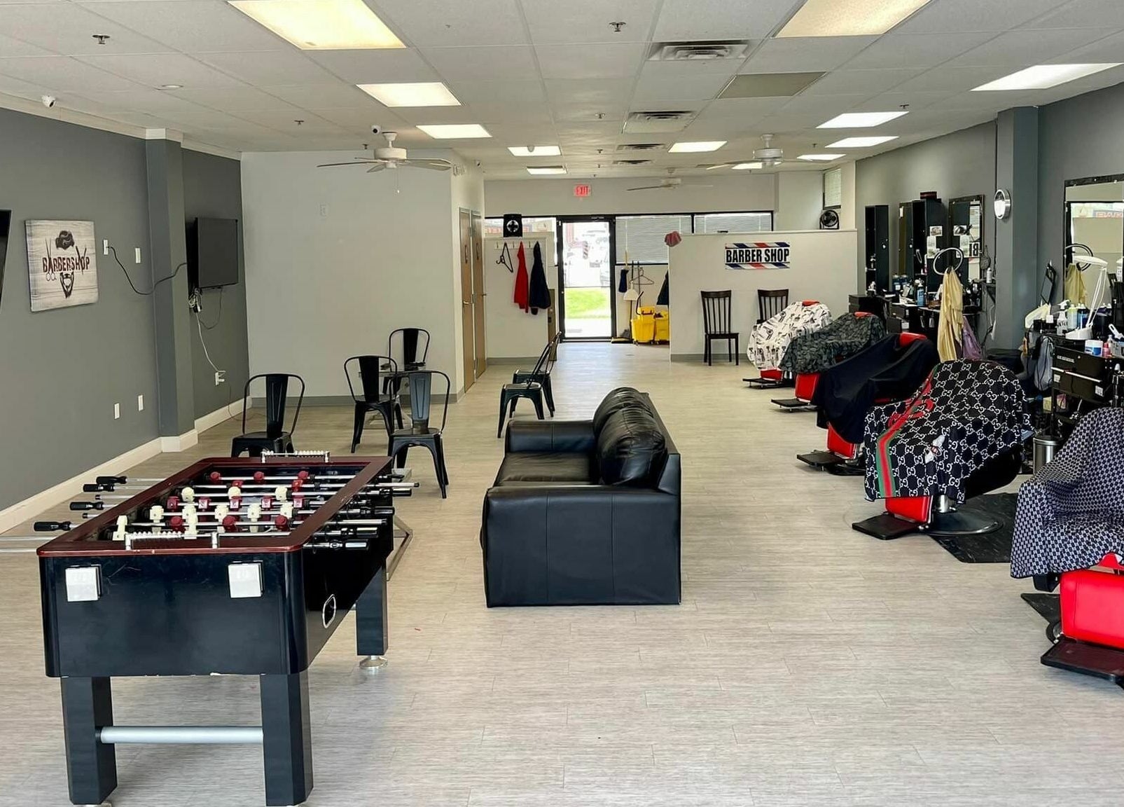Modern interior of The Maple Barbers in Omaha, Nebraska, US, featuring stylish chairs and entertainment.