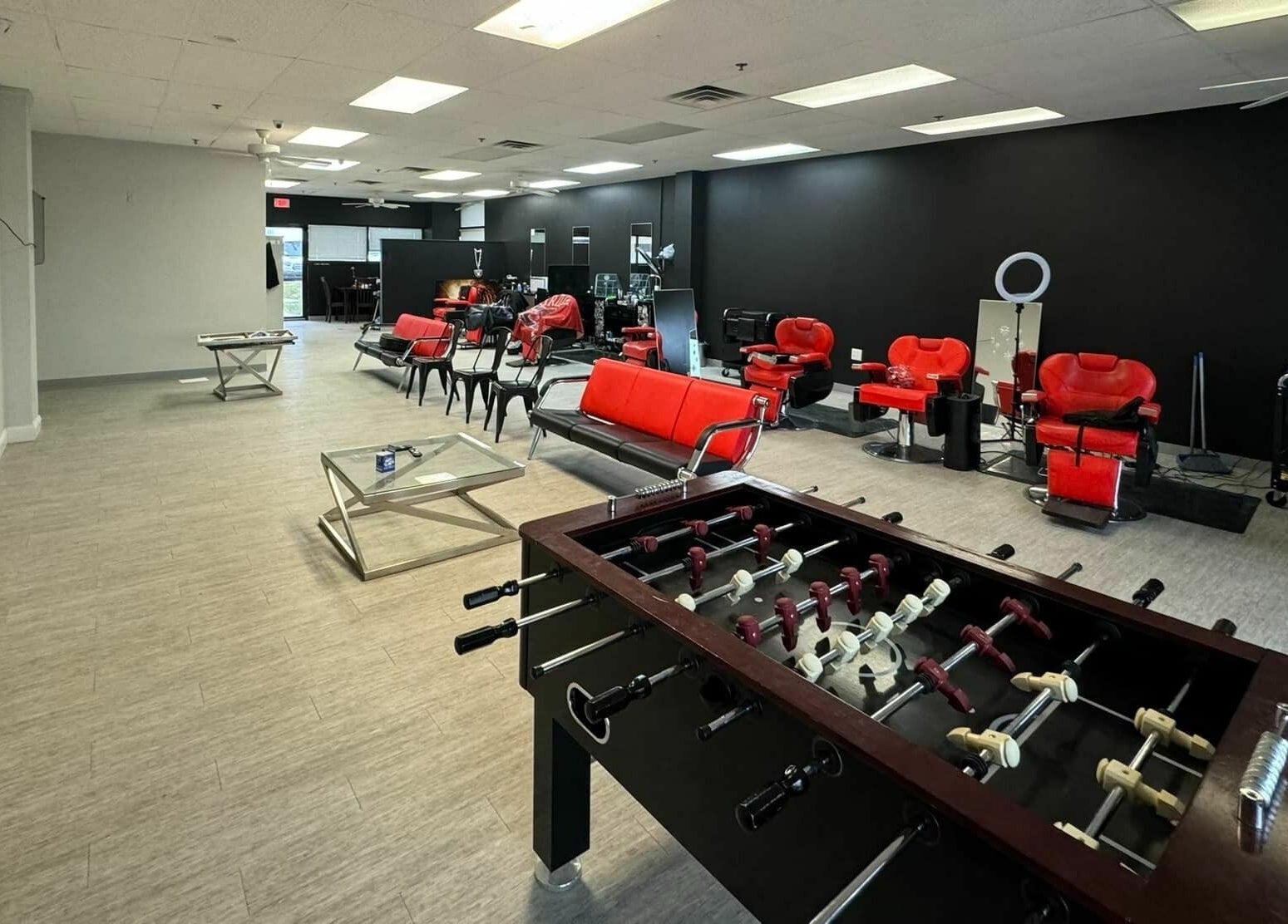 The Maple Barbers in Omaha, Nebraska, US with stylish red chairs and foosball table for a unique experience.