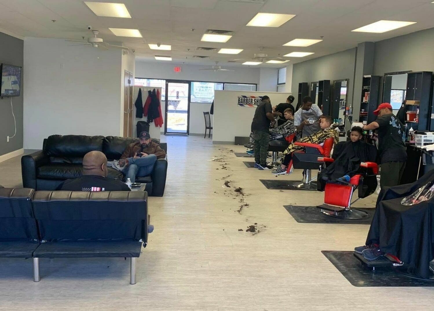 Cozy interior of The Maple Barbers, Omaha, Nebraska, US, featuring clients receiving haircuts.