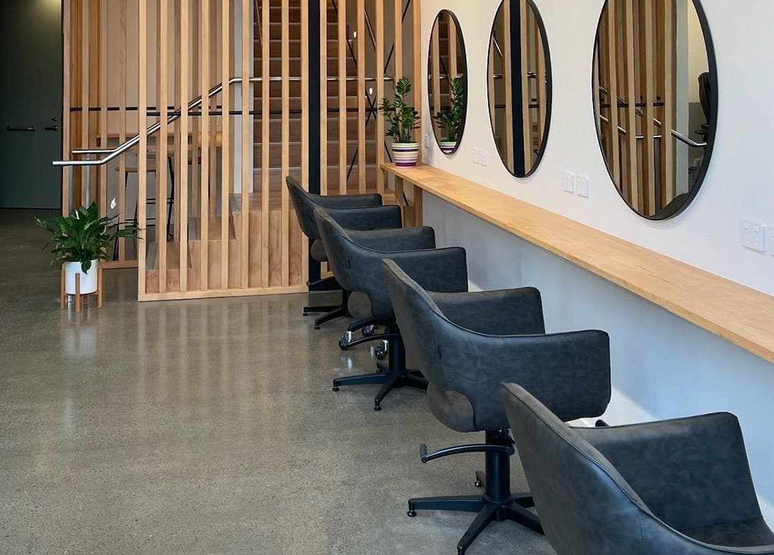 Chic salon seating at Beutiq, Wellington, Wellington, NZ, featuring round mirrors and modern decor.
