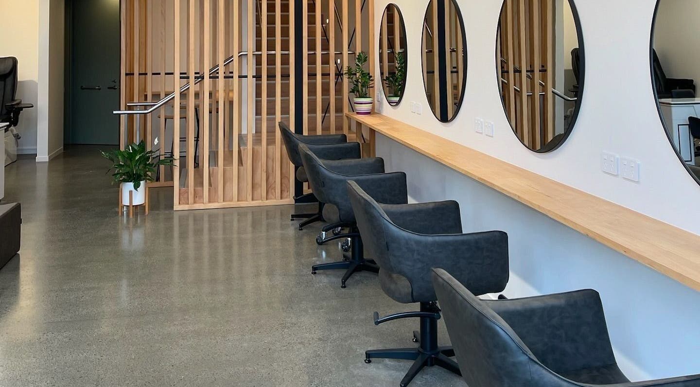 Chic salon seating at Beutiq, Wellington, Wellington, NZ, featuring round mirrors and modern decor.