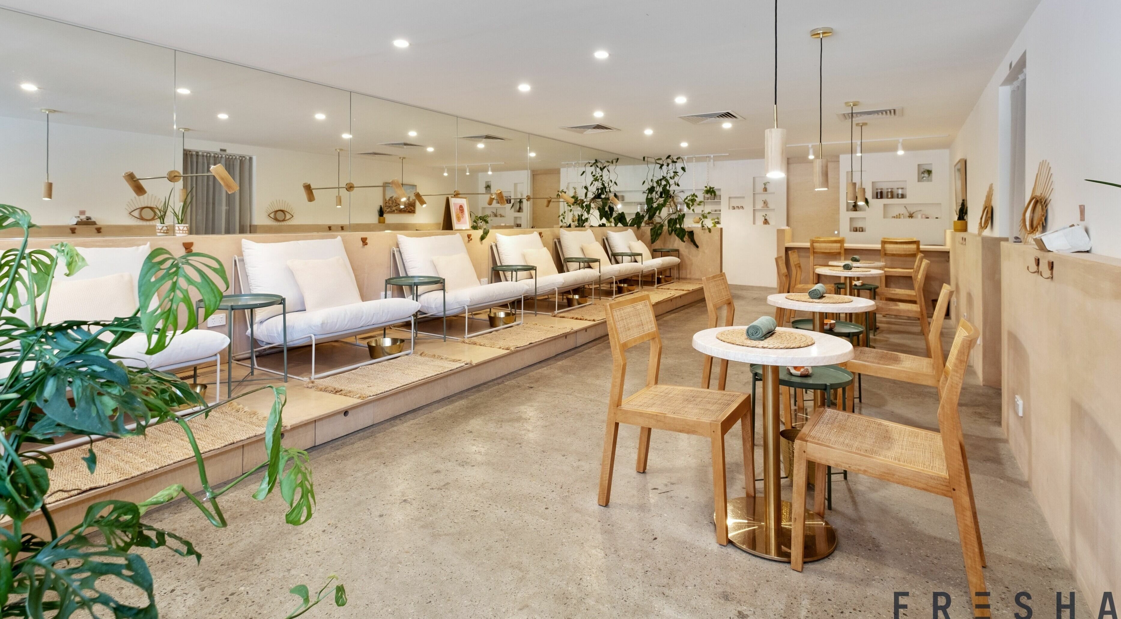 Modern and cozy seating area at ERVA Nail Spa, Burleigh Heads, Queensland, AU, with greenery and wooden accents.