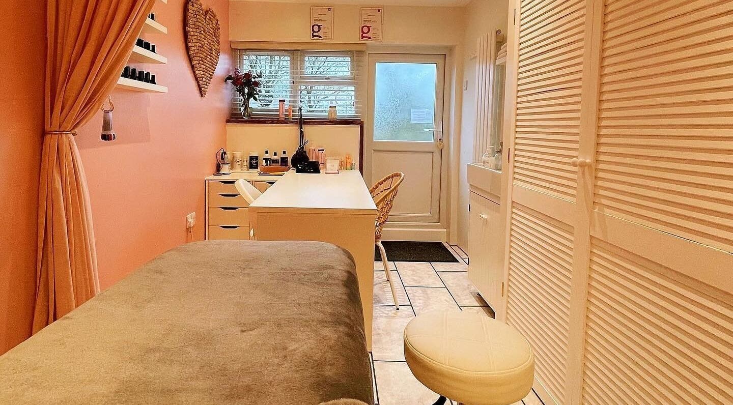 Cozy treatment room at The Beauty Garage, Caversfield, England, tranquil ambiance with soft peach tones.