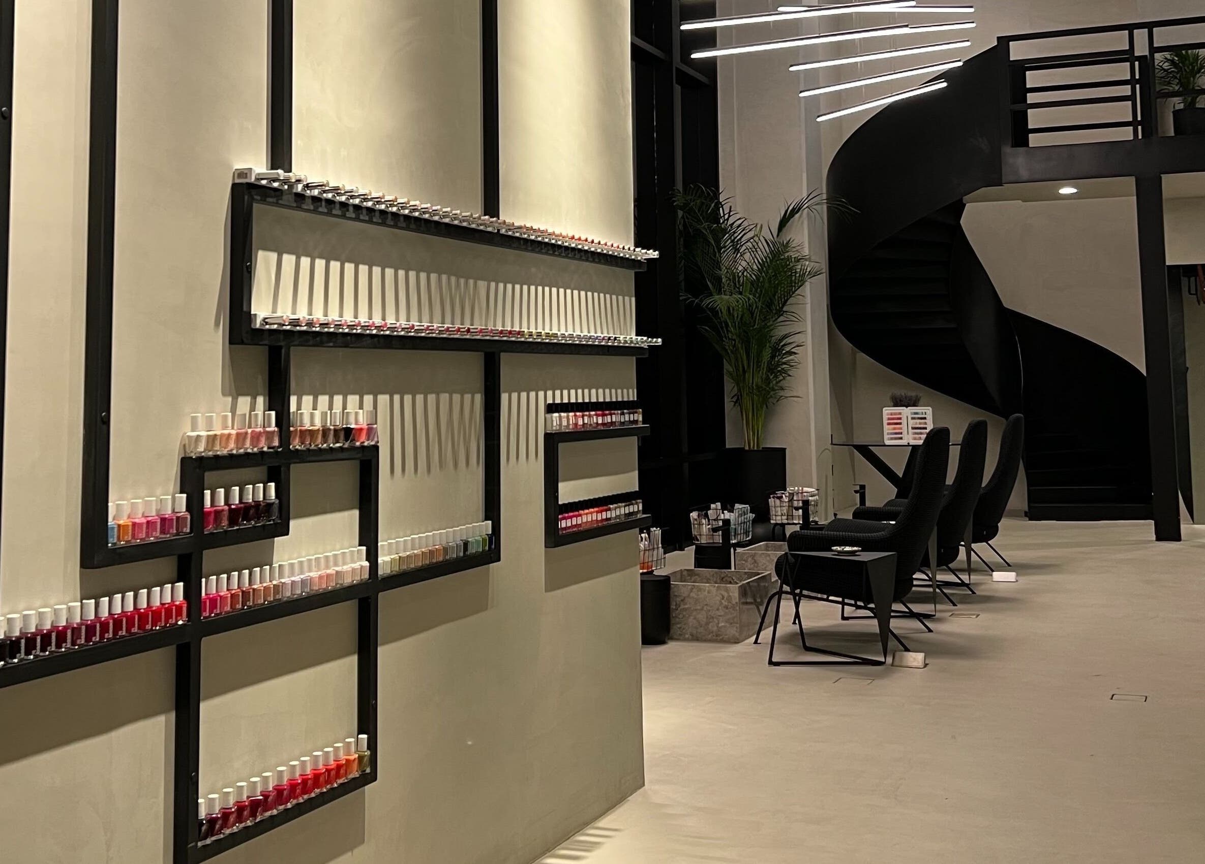Modern salon interior at Ink Brows and Beauty - Riyadh with nail polish display and spiral staircase, Riyadh Province, SA.