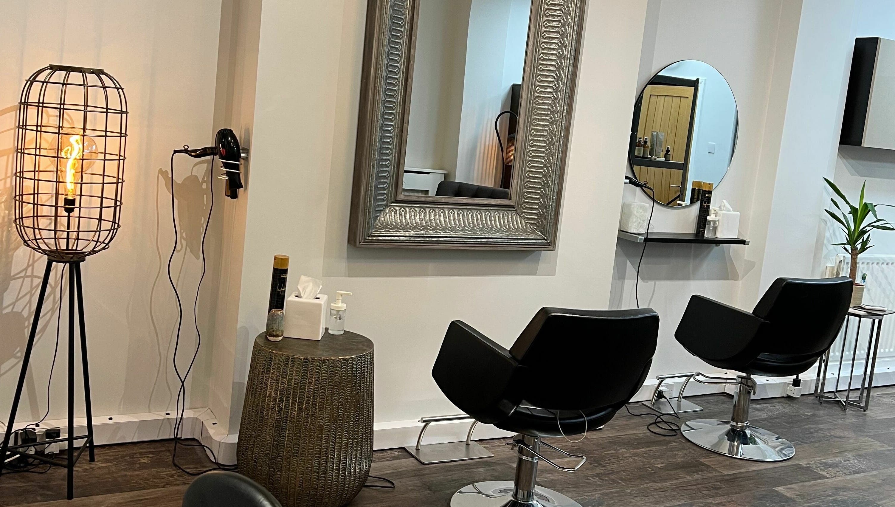 Elegant styling chairs at Tom Syed Hair Spa in Stourbridge, England, GB with mirrors and modern lighting.
