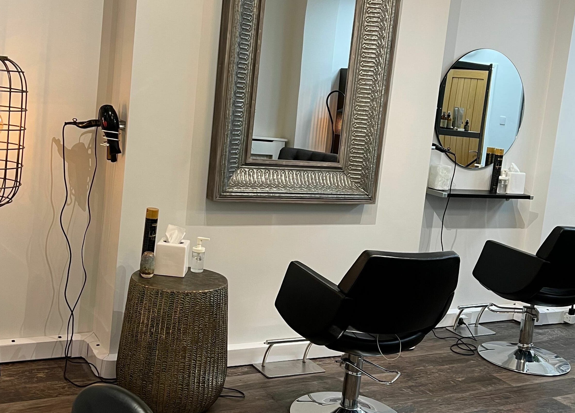 Elegant styling chairs at Tom Syed Hair Spa in Stourbridge, England, GB with mirrors and modern lighting.