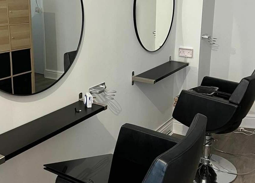 Elegant salon chairs and mirrors at Tom Syed Hair Spa, Stourbridge, England, GB, showcasing modern design.