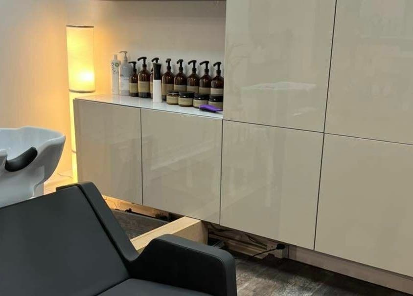 Elegant wash area at Tom Syed Hair Spa, Stourbridge, England, GB with modern chair and product display.