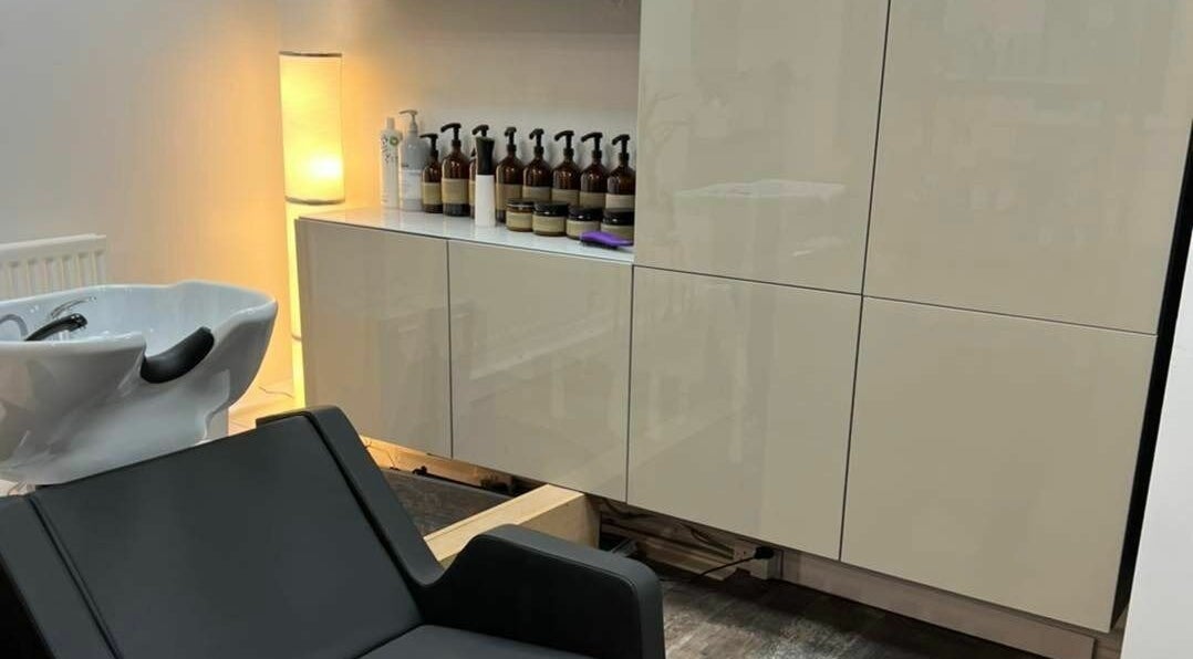 Elegant wash area at Tom Syed Hair Spa, Stourbridge, England, GB with modern chair and product display.
