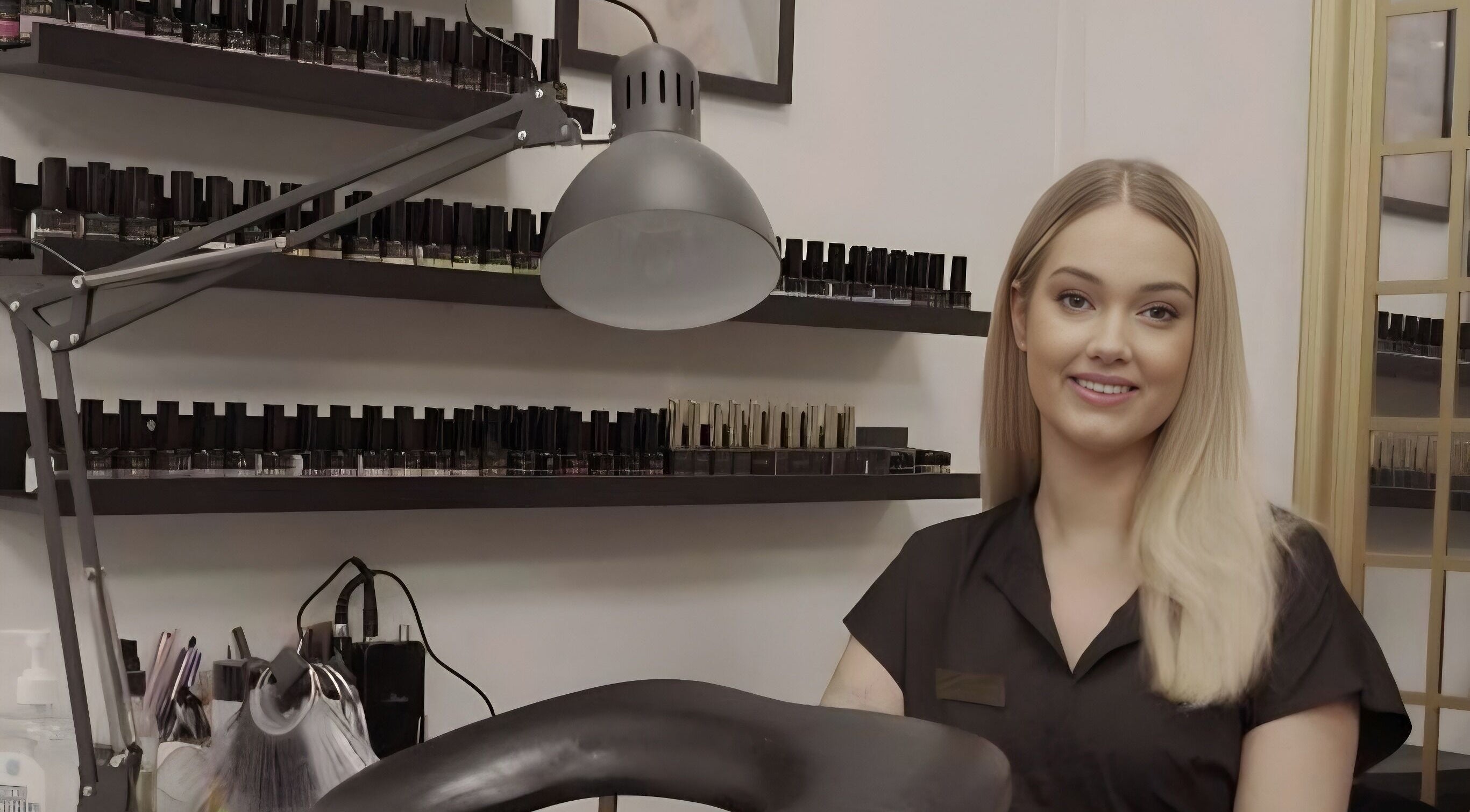 Nail artist in Beauty by Gab, Bargoed, GB, smiling in front of polish collection.