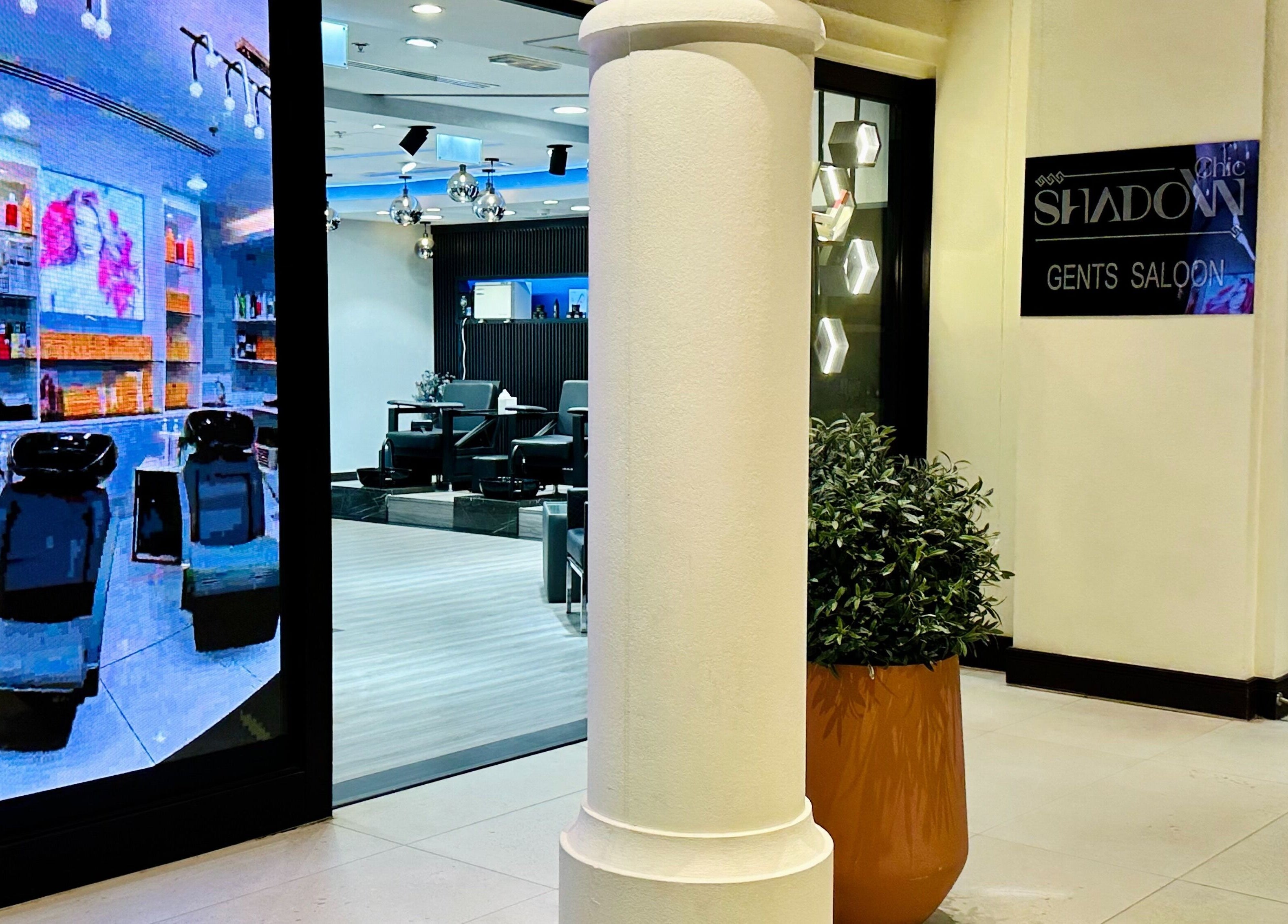 Entrance to Shadow Chic Gents salon in Dubai, Dubai, AE. Modern chairs and stylish decor visible inside.