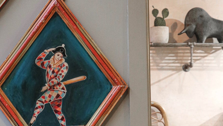Artistic wall decor at Cuttlefish Eco Salon - Lewes, featuring a colorful harlequin painting, Lewes, England, GB.